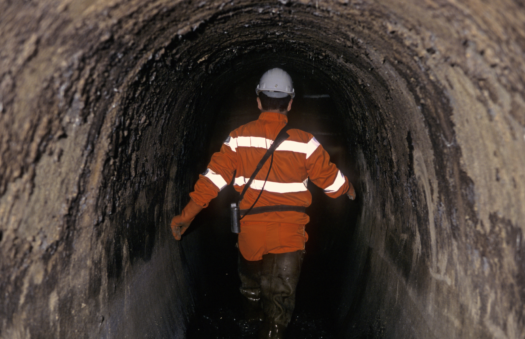 man wearing visor walking in sewer