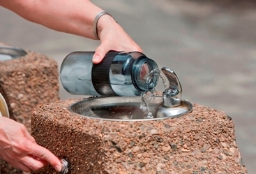 water bottle being filled up at water fountain
