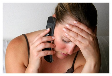 Woman on phone with hand on forehead