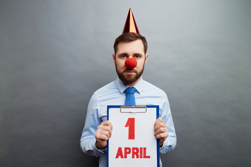 Businessman wearing clowns nose and party hat showing April fools day date