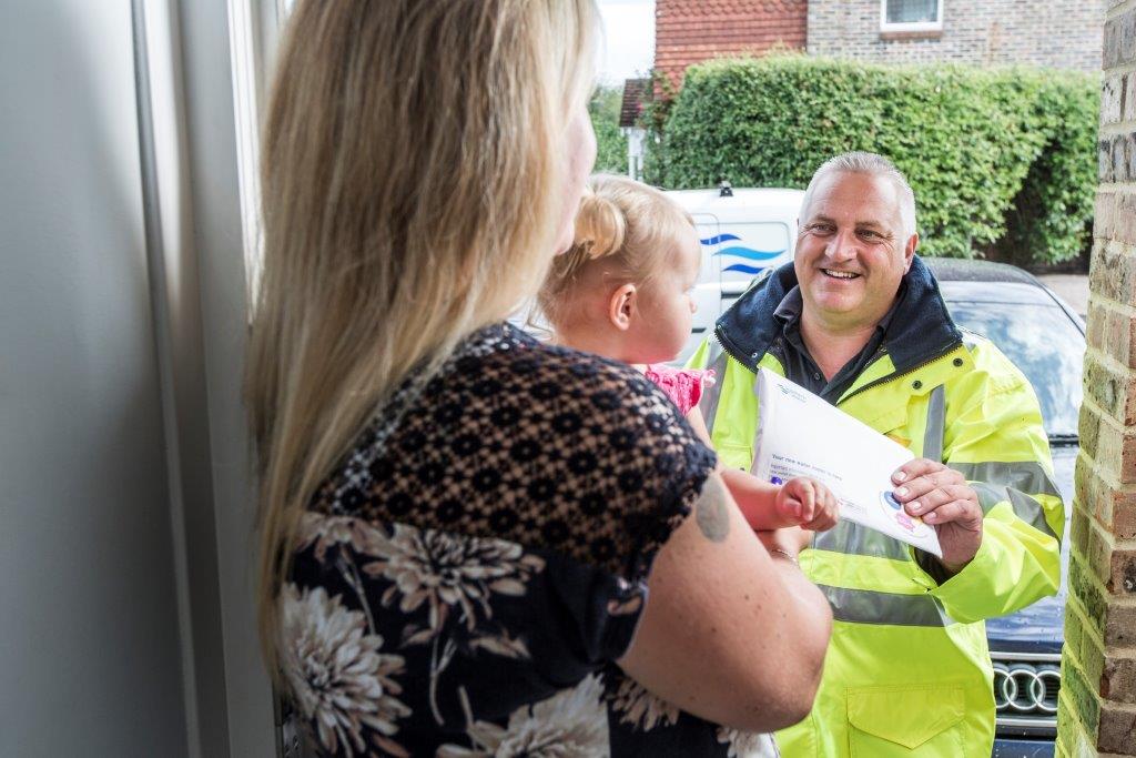 woman opening door to man in yellow jacket