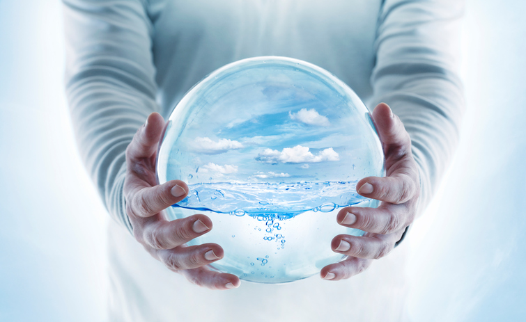 Transparent globe with water in human hands.