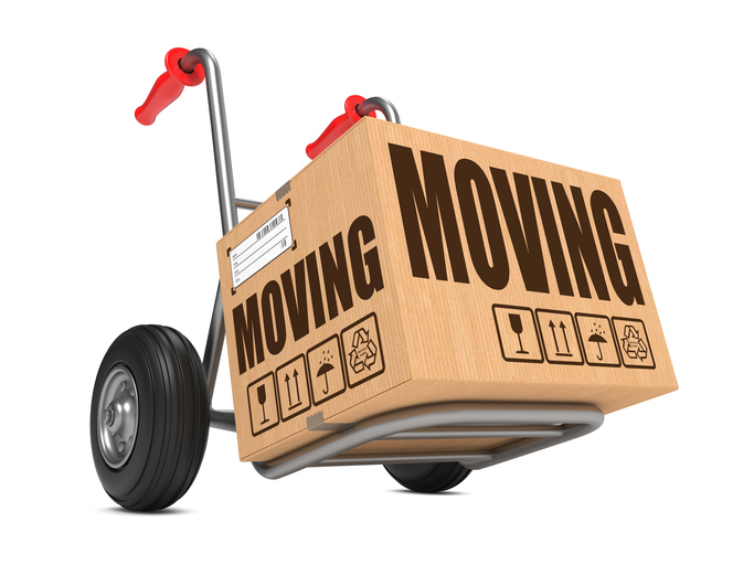 Moving - Slogan on Cardboard Box on Hand Truck White Background.