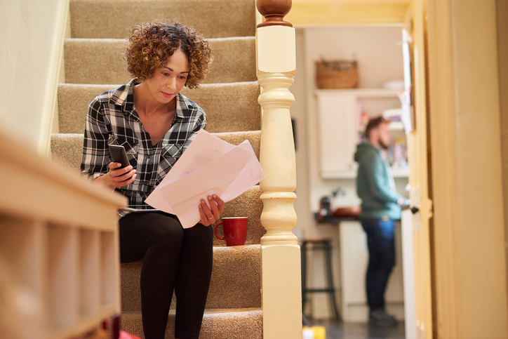 a woman sits on the stairs of her home