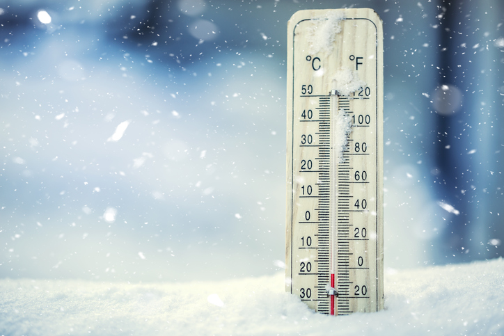 Thermometer on snow shows low temperatures under zero.