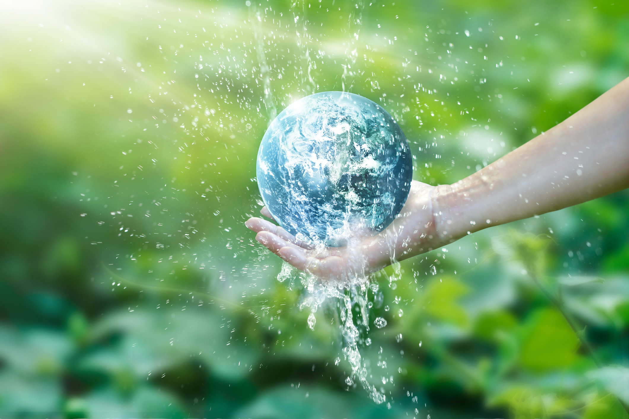 Water pouring on planet earth placed on human hand for saving resources and heal the world campaign, environment issues, Elements of this image furnished by NASA.