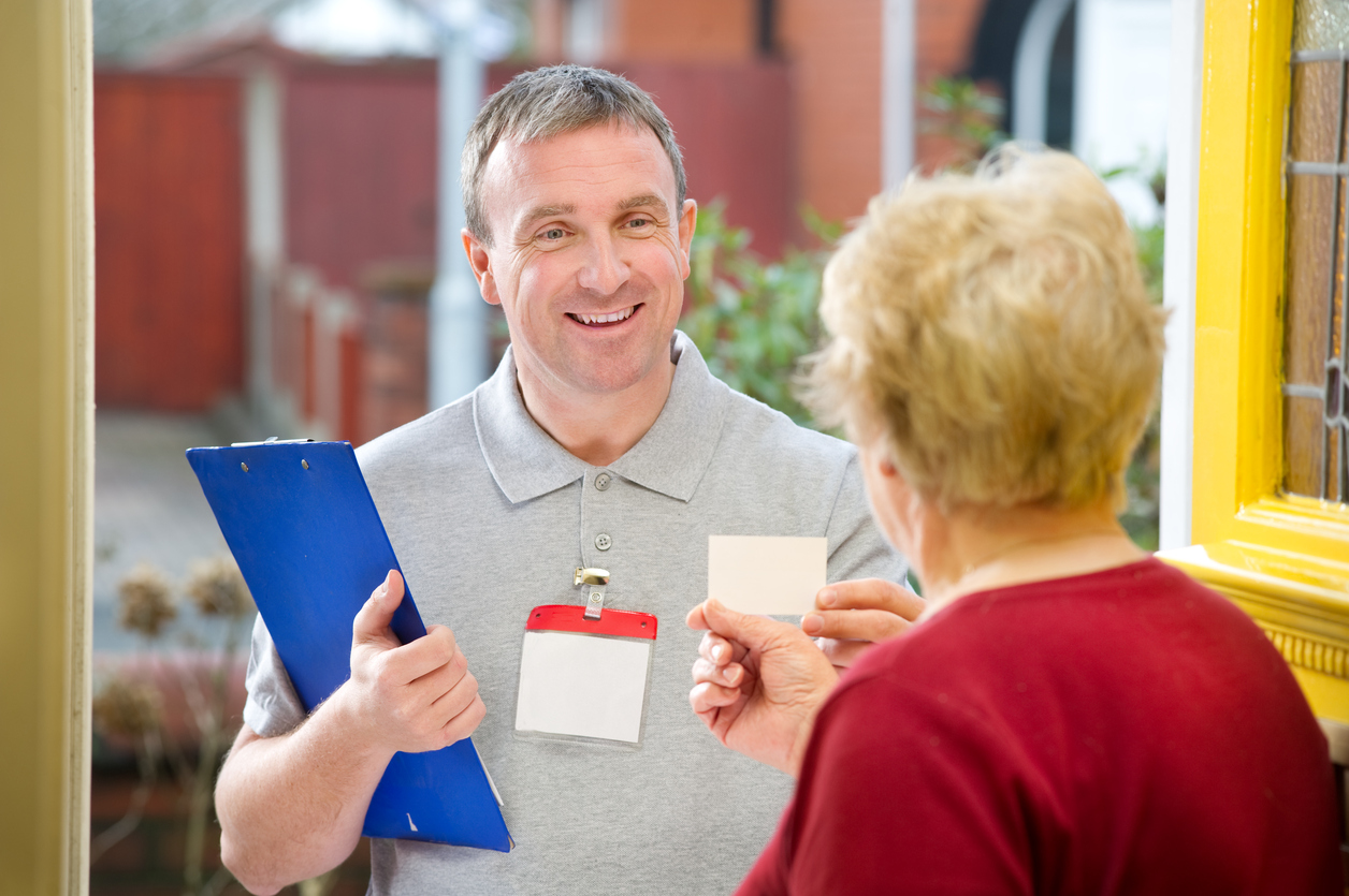 Smiling salesman shows senior woman his card