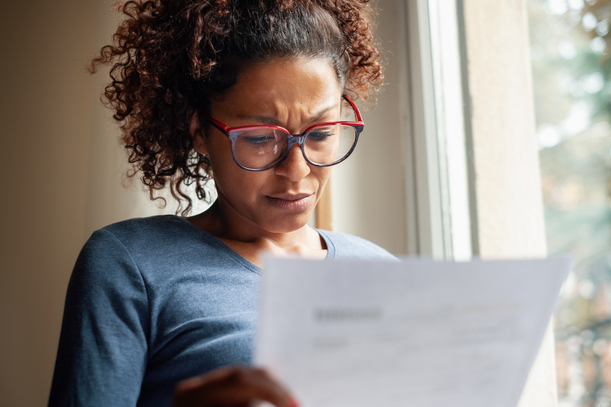 Portrait of worried black woman standing beside window