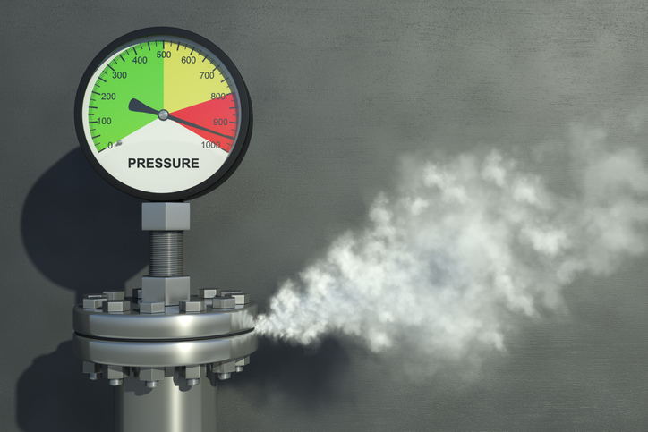 Gas or steam leaking from an industrial pressure gauge.