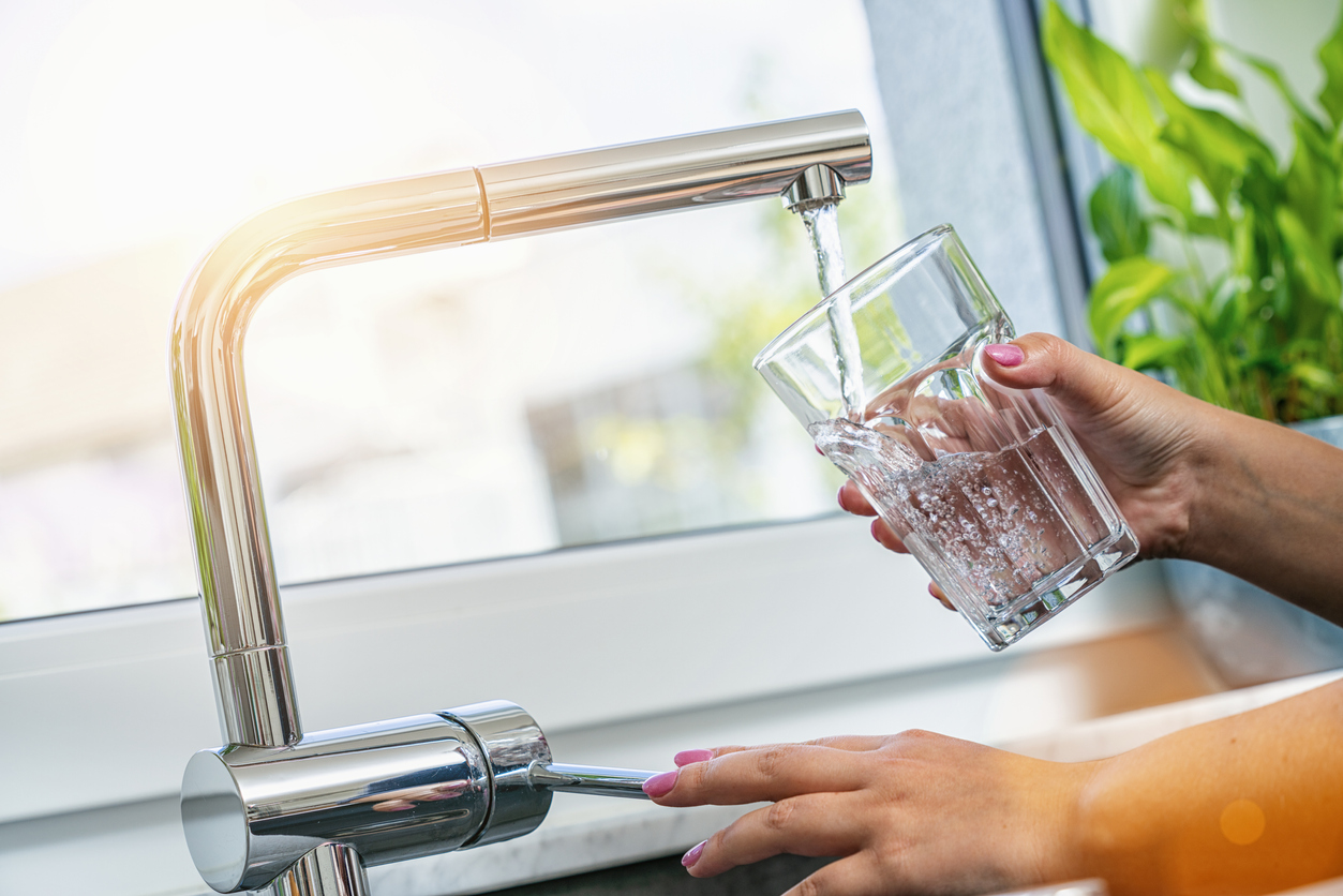 woman filling glass with water