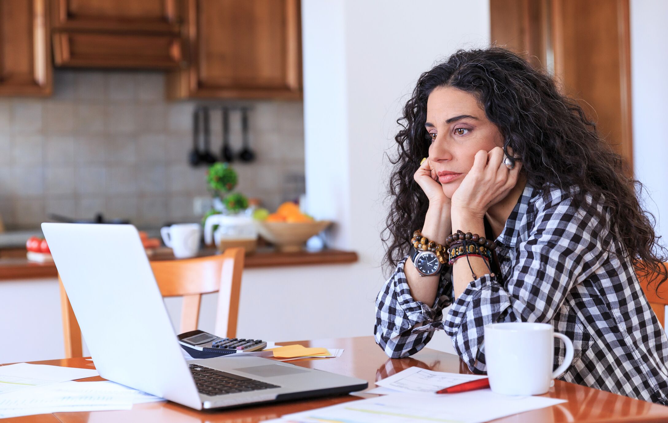 Lady looking at laptop worrying about finances