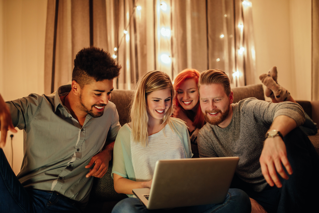 four students around a laptop