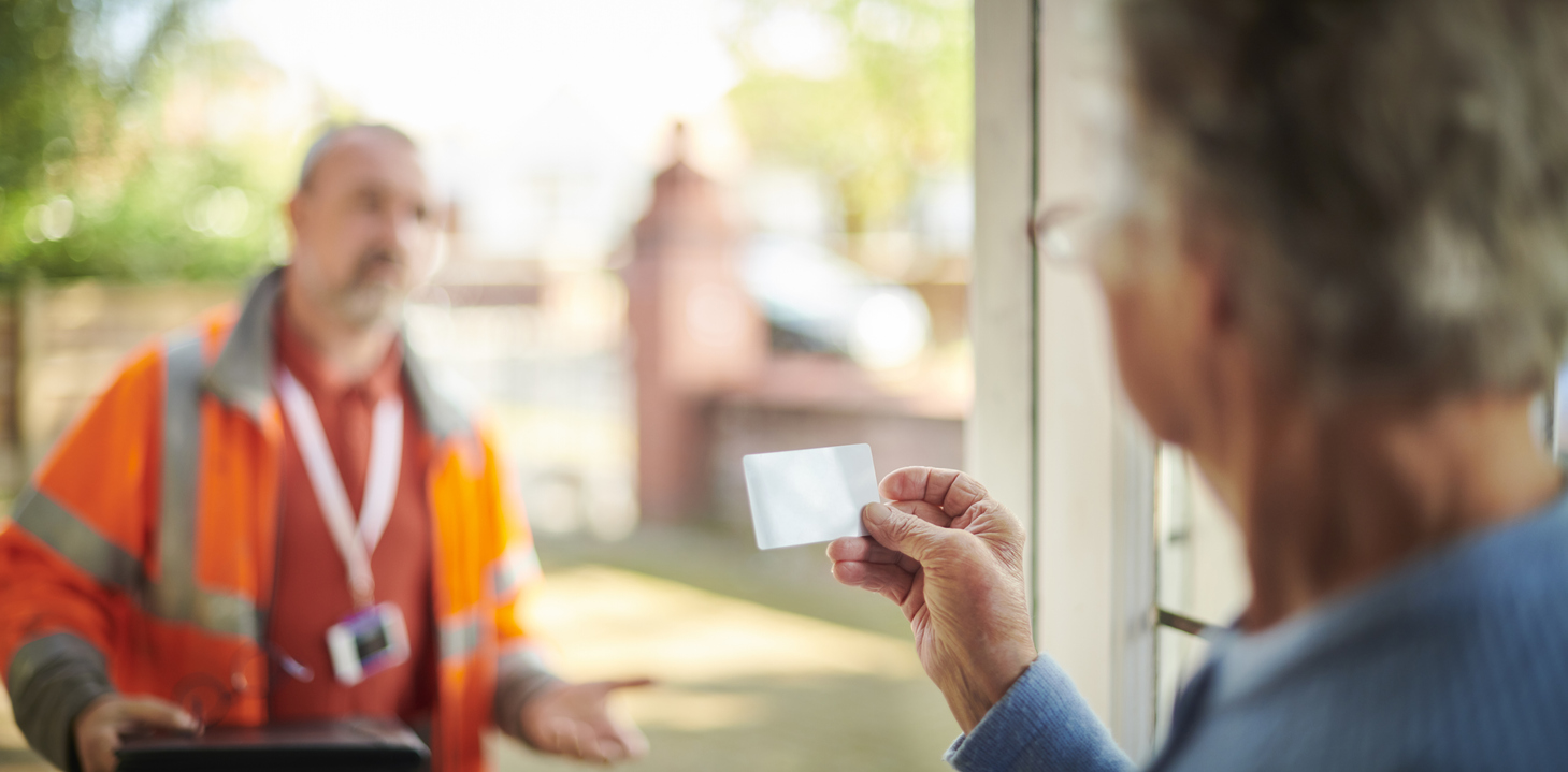 Woman checking ID card of tradesperson