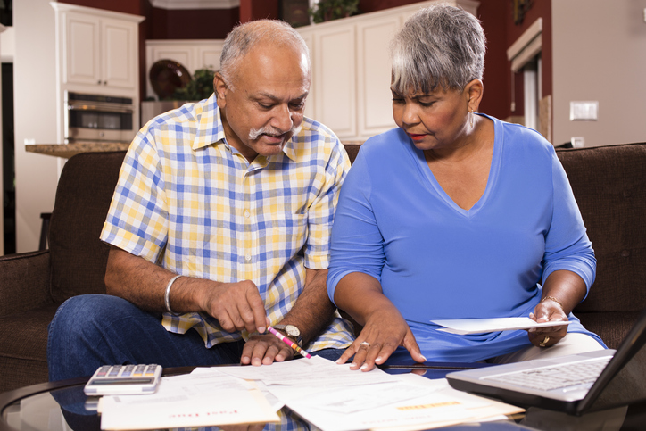 indian man and african woman looking at bills together in the home