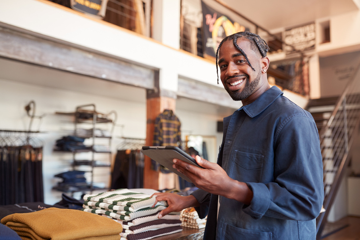 Portrait Of Male Owner Of Fashion Shop Using Tablet