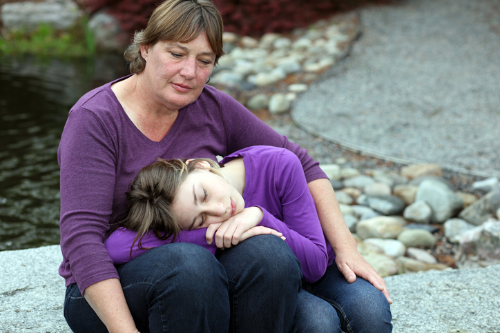 A mother and daughter comfort each other after a sewer flooding incident