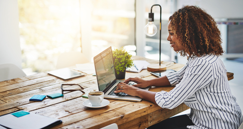 Woman using laptop on a wooden table