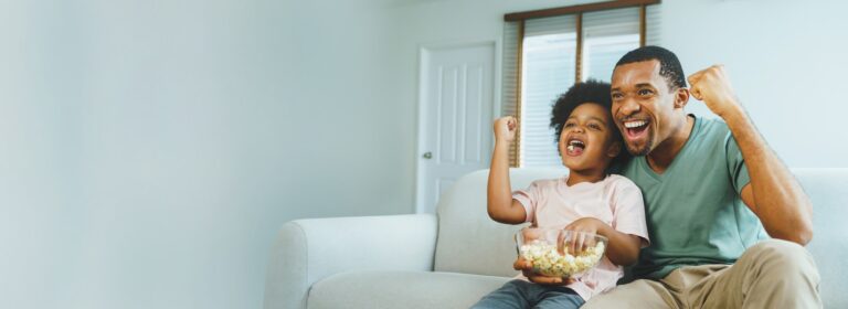 Cheerful African American Father and his little boy together at home celebrating