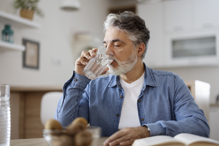 Man drinking water in kitchen