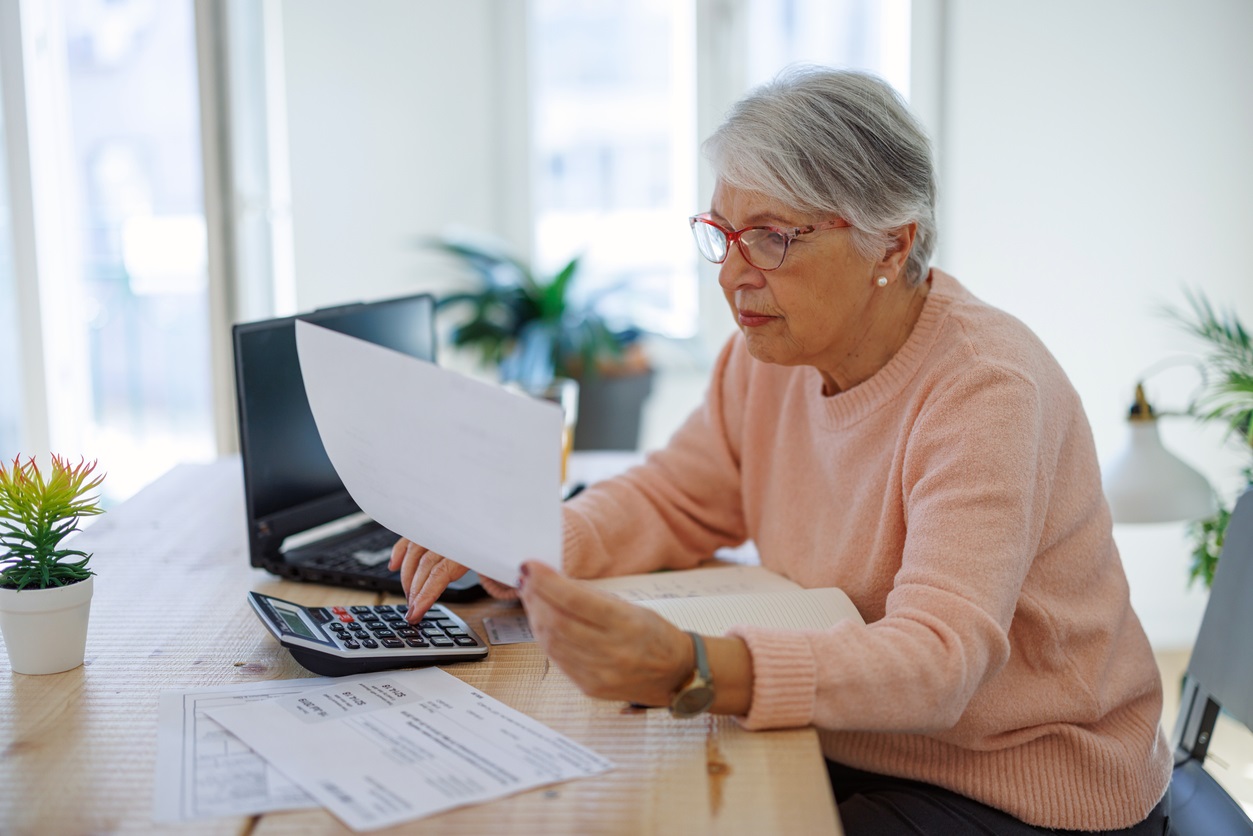 Woman at table looking at a bill