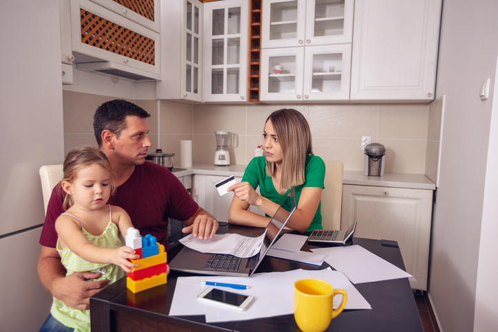 young couple with daughter planning home budget