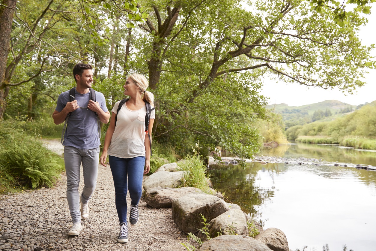 Couple walking by a river bank