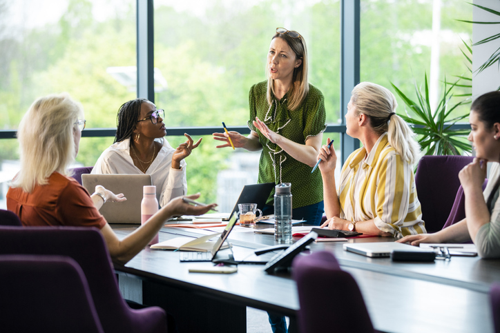 Group of women in a meeting room working together and discussing ideas