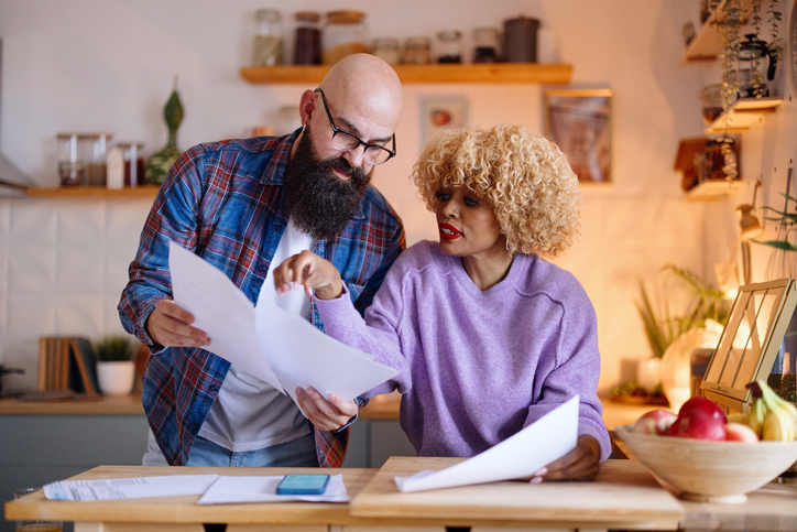 Multiracial couple discussing future expenses at home