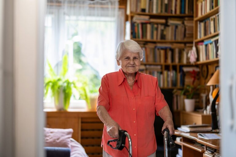 Senior woman with walker standing in her room