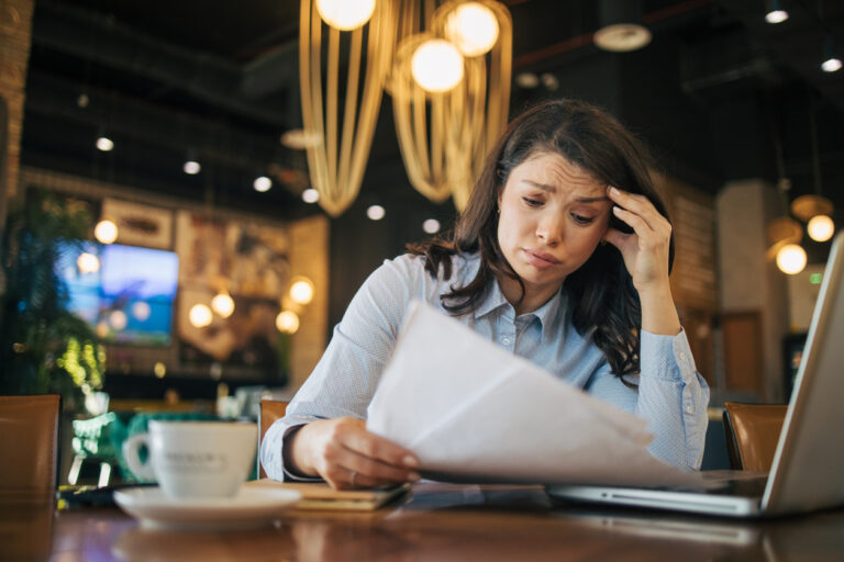 Worried businesswoman working on reports in a cafe