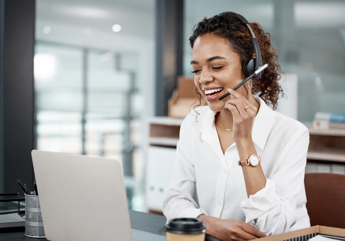 Young female call center agent working at her desk in the office