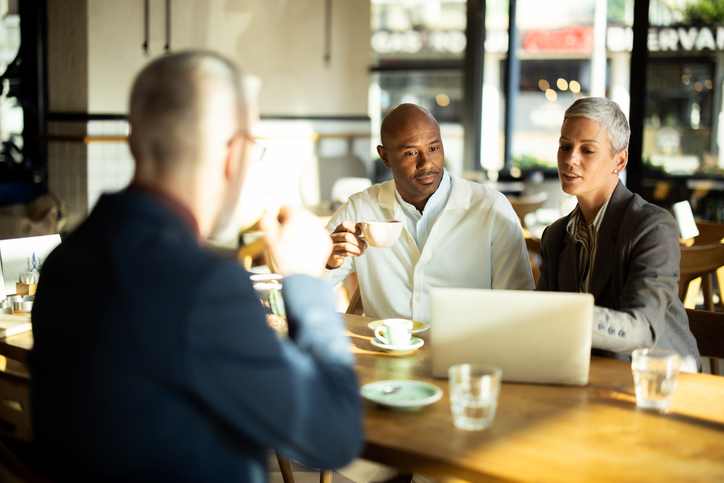 Business partners discussing a project over coffee at a cafe