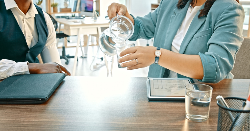Pouring, water or hands of business people in meeting in office.