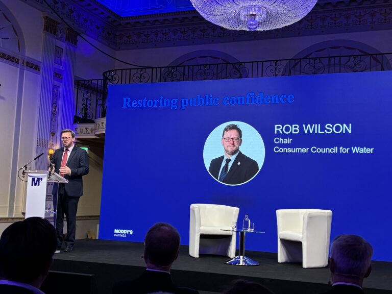 CCW Chair Rob Wilson stands at a lectern addressing the audience at Moody's UK Water conference.