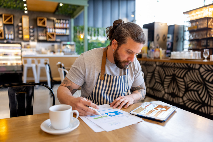 business manager paying financial bills at a coffee shop