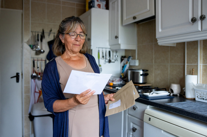 senior woman at home checking a letter in the mail